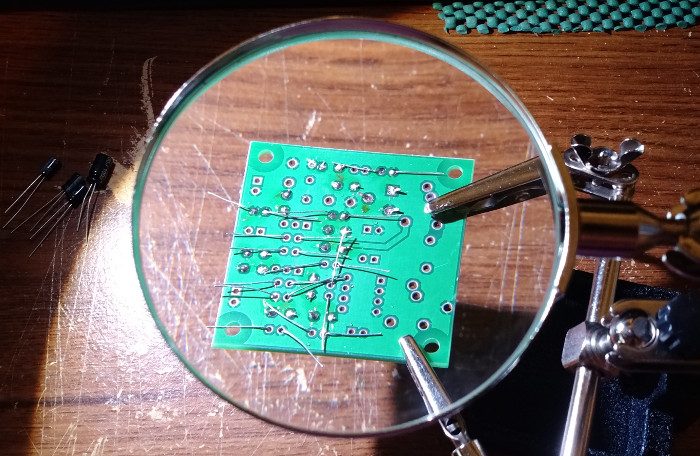 The solder side through the Helping Hands magnifying glass.